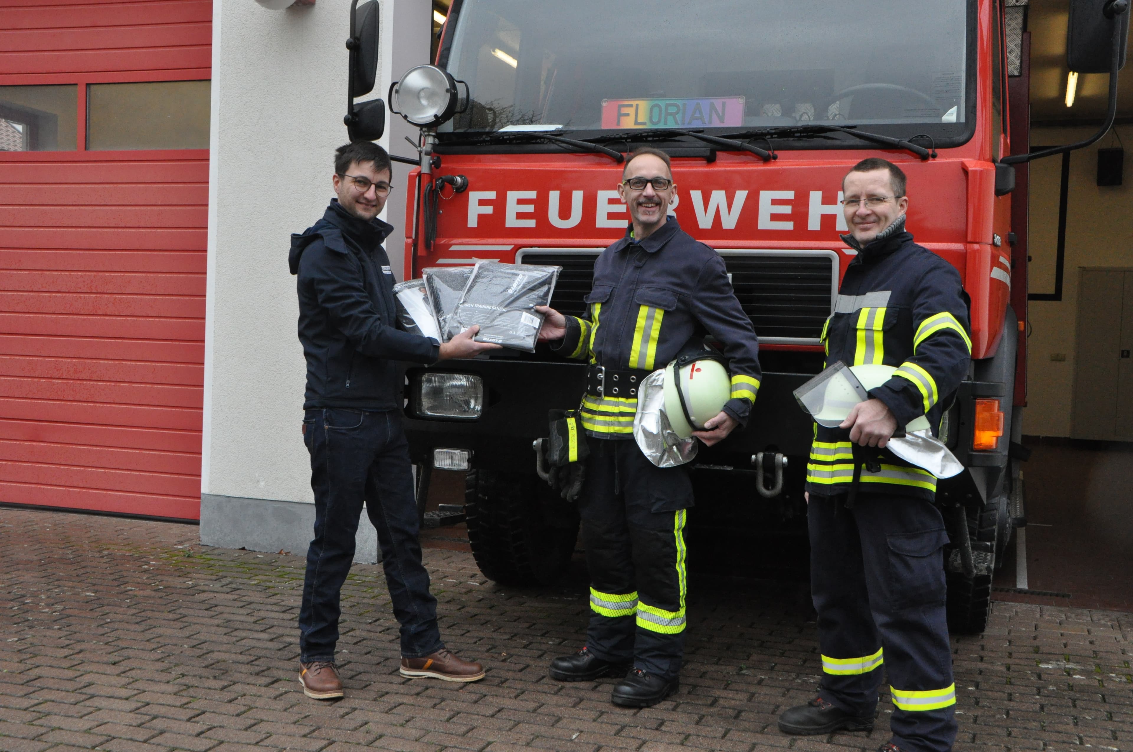 Vereinsvorsitzender überreicht Trainingsanzüge